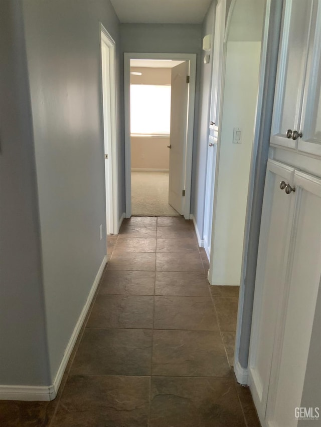 5322 Windriver Dr, Bakersfield, CA 93312 - hallway featuring baseboards and dark stone finish floors