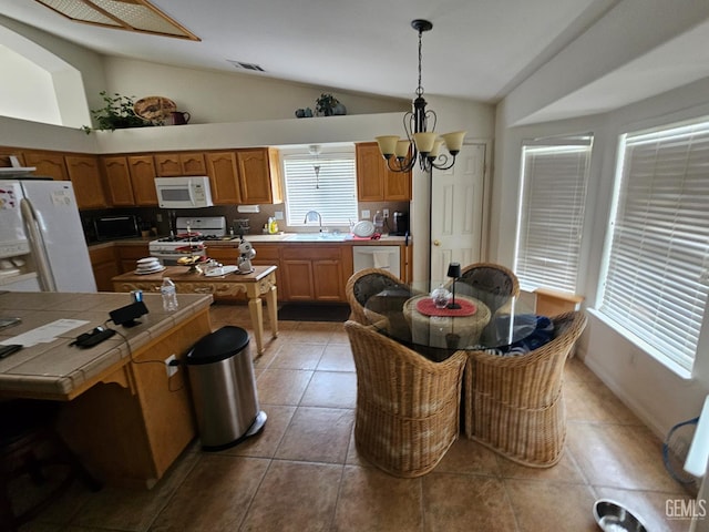 4102 Sierra Redwood Dr, Bakersfield, CA 93313 - kitchen featuring white appliances, tile counters, lofted ceiling, light tile patterned floors, and a chandelier