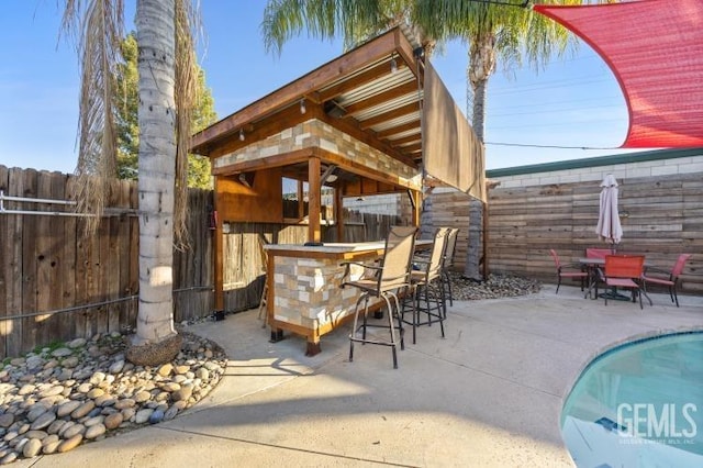 view of patio / terrace with a fenced in pool and a bar