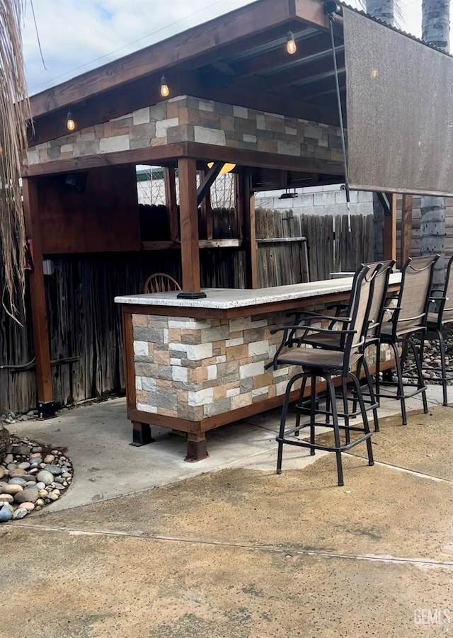 view of patio with fence and outdoor dry bar