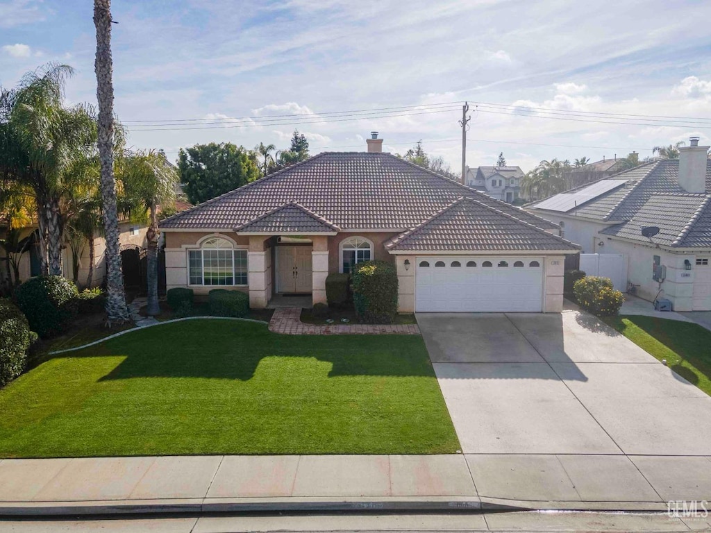 view of front of property featuring a garage and a front lawn