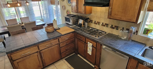 5308 Benevento Ct, Bakersfield, CA 93308 - kitchen featuring a toaster, stainless steel appliances, tile countertops, brown cabinetry, and tasteful backsplash