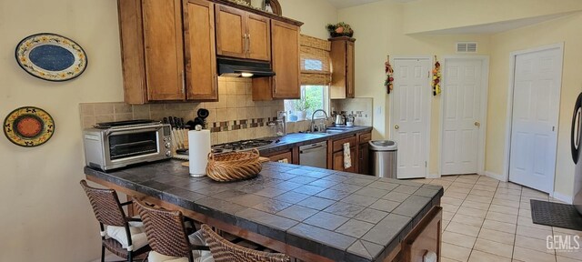 5308 Benevento Ct, Bakersfield, CA 93308 - kitchen featuring tile counters, a toaster, visible vents, dishwasher, and under cabinet range hood