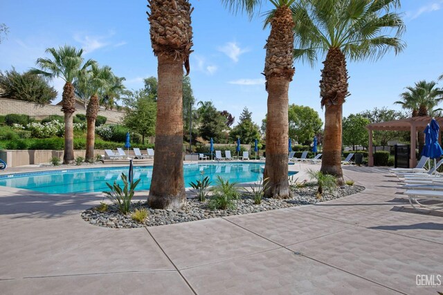 community pool with a patio and fence