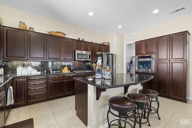 kitchen featuring light tile patterned floors, visible vents, appliances with stainless steel finishes, and a center island