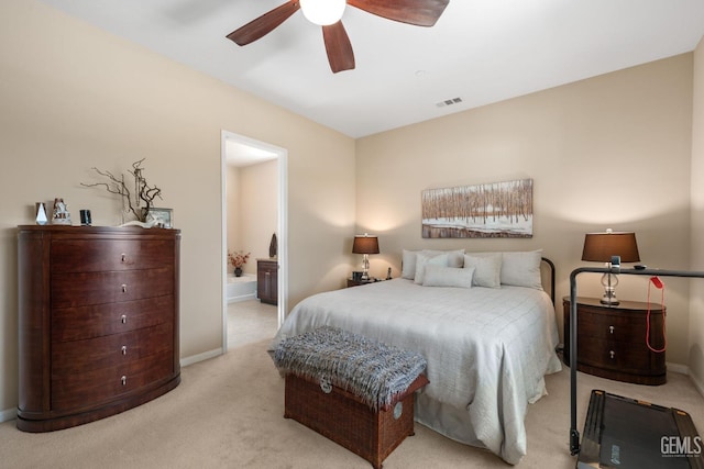 carpeted bedroom featuring baseboards, visible vents, ensuite bathroom, and ceiling fan