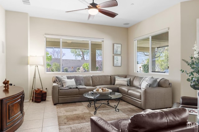 living area with a healthy amount of sunlight, ceiling fan, and light tile patterned flooring