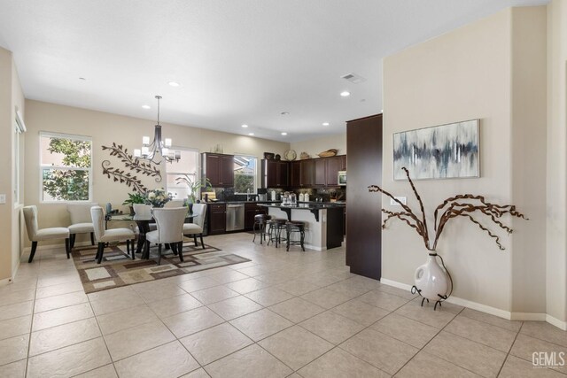 dining area featuring light tile patterned floors, visible vents, and a chandelier