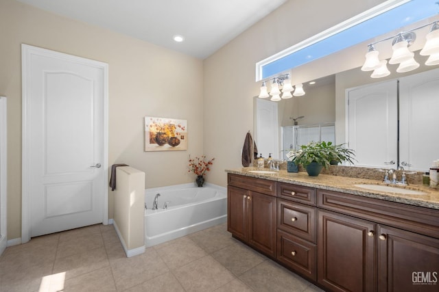 bathroom with tile patterned flooring, double vanity, a bath, and a sink