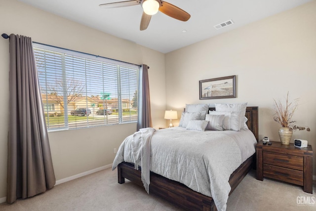 bedroom with visible vents, baseboards, light colored carpet, and ceiling fan