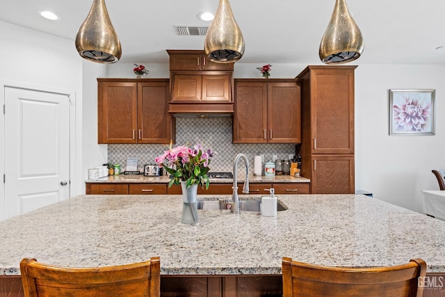 7900 Linden Tree Ave, Bakersfield, CA 93313 - kitchen featuring decorative backsplash, a large island with sink, visible vents, and a sink