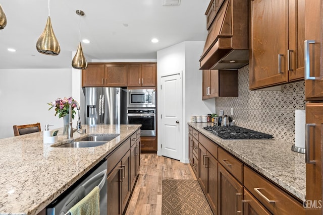 7900 Linden Tree Ave, Bakersfield, CA 93313 - kitchen featuring light wood finished floors, stainless steel appliances, a sink, backsplash, and custom range hood