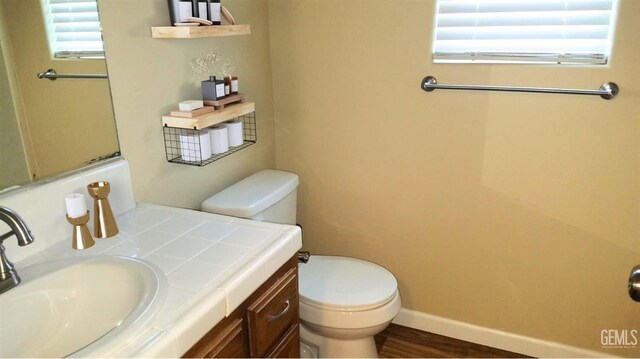 9057 Mackenzie Ct, Bakersfield, CA 93306 - bathroom with toilet, vanity, wood finished floors, and baseboards
