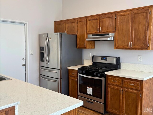 9057 Mackenzie Ct, Bakersfield, CA 93306 - kitchen with stainless steel appliances, under cabinet range hood, light countertops, brown cabinets, and a sink