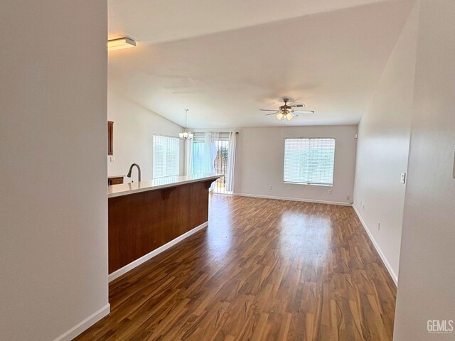 9057 Mackenzie Ct, Bakersfield, CA 93306 - unfurnished living room featuring dark wood-style flooring, baseboards, a chandelier, and a ceiling fan