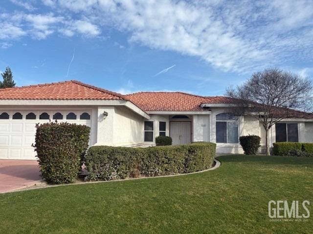 mediterranean / spanish-style house with concrete driveway, a tile roof, an attached garage, a front lawn, and stucco siding