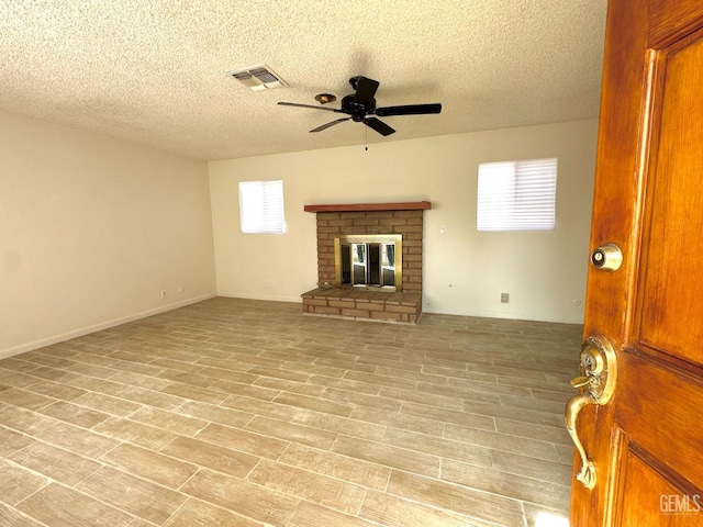 615 Cypress St, Bakersfield, CA 93304 - unfurnished living room featuring a ceiling fan, a textured ceiling, a fireplace, and light wood finished floors