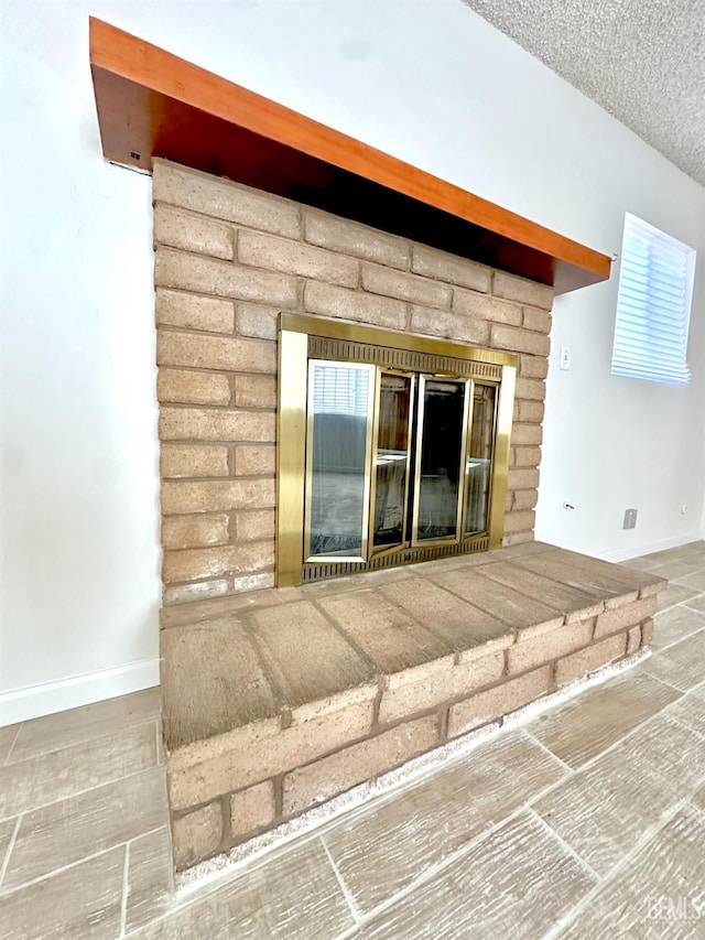 615 Cypress St, Bakersfield, CA 93304 - detailed view of a fireplace, baseboards, and a textured ceiling
