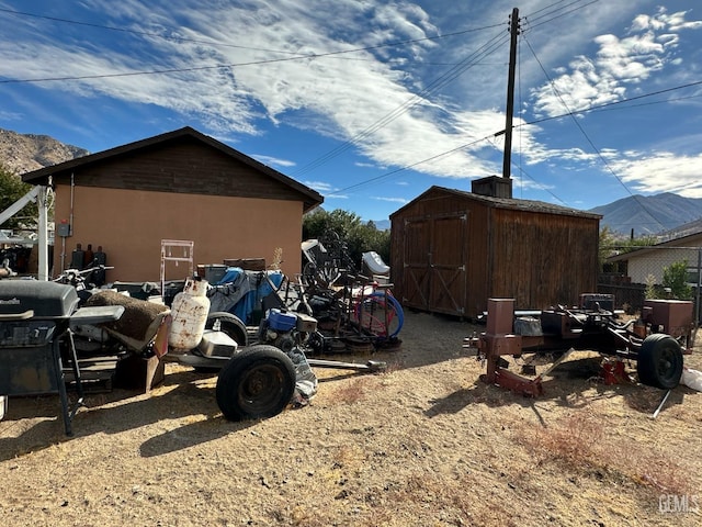 view of home's exterior featuring a mountain view and a storage shed