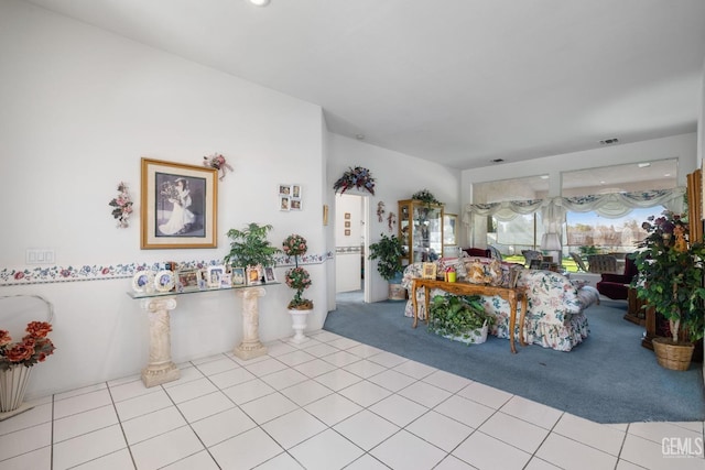 living room featuring light tile patterned flooring, visible vents, and light colored carpet