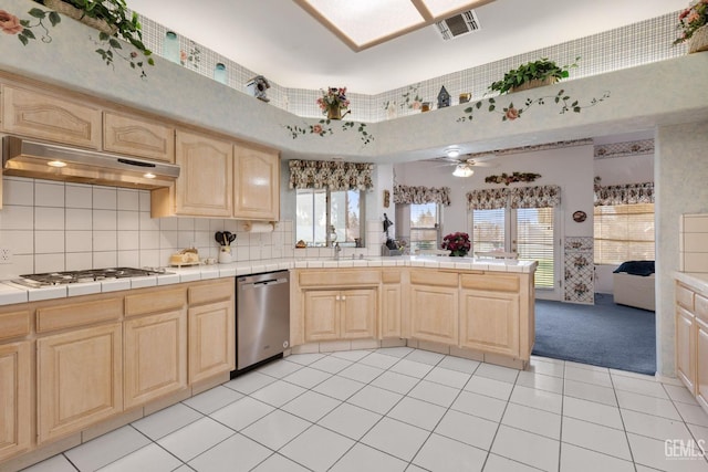 kitchen with tile countertops, visible vents, light brown cabinetry, dishwasher, and under cabinet range hood