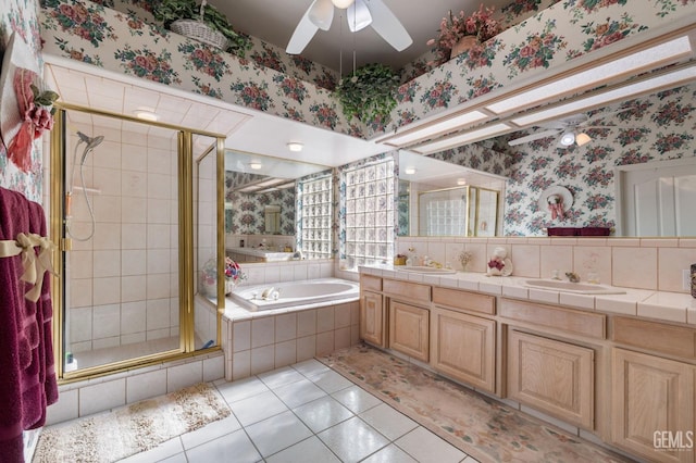 bathroom featuring a stall shower, a sink, a bath, and wallpapered walls