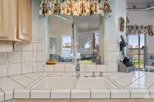 kitchen featuring tasteful backsplash, light brown cabinets, and tile counters