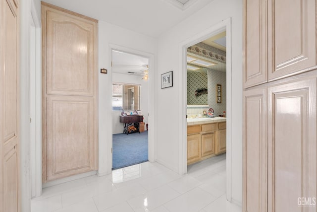 hallway with light tile patterned floors and light colored carpet