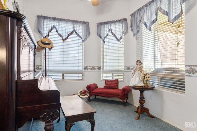 sitting room with carpet flooring, plenty of natural light, and baseboards