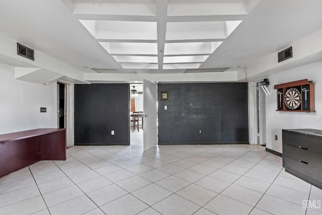 unfurnished living room featuring tile patterned flooring, visible vents, and coffered ceiling