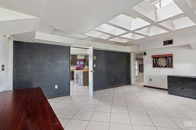 unfurnished living room featuring visible vents, light tile patterned flooring, a sink, coffered ceiling, and baseboards