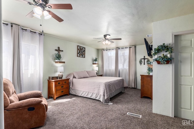 bedroom with visible vents, a ceiling fan, carpet floors, and a textured ceiling
