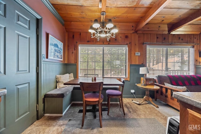 dining area featuring a healthy amount of sunlight, wooden ceiling, and an inviting chandelier