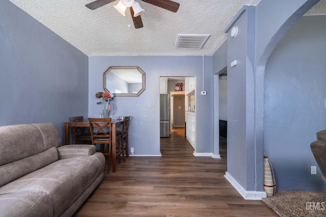 819 P St, Bakersfield, CA 93304 - living area with arched walkways, ceiling fan, wood finished floors, a textured ceiling, and baseboards