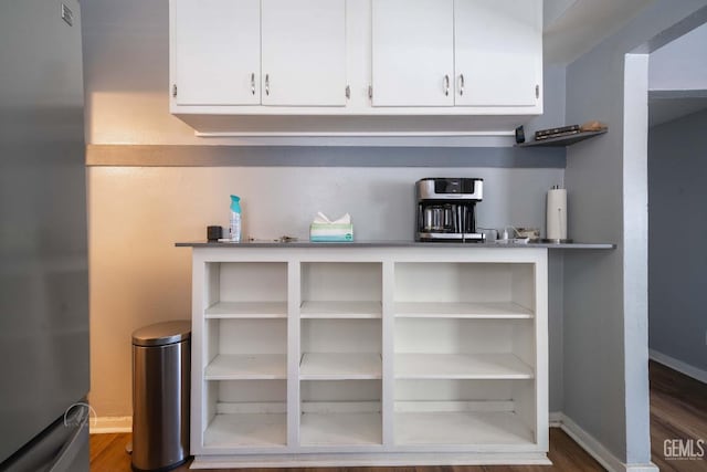 819 P St, Bakersfield, CA 93304 - bar featuring freestanding refrigerator, dark wood-style flooring, and baseboards
