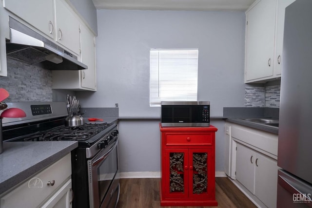 819 P St, Bakersfield, CA 93304 - kitchen with stainless steel appliances, under cabinet range hood, white cabinetry, dark wood-type flooring, and tasteful backsplash