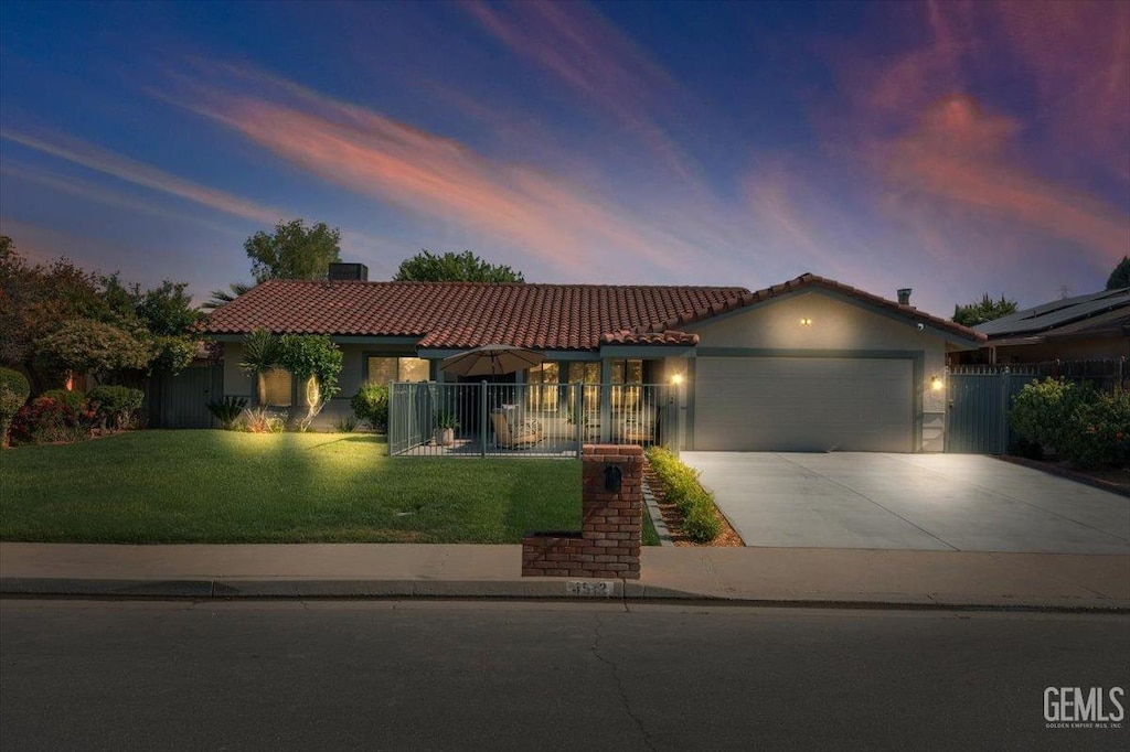 4512 University Ave, Bakersfield, CA 93306 - mediterranean / spanish home with a tiled roof, a garage, driveway, and stucco siding