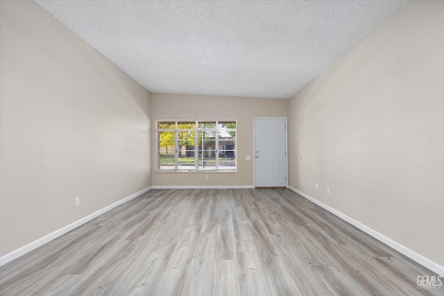 unfurnished room with a textured ceiling and light wood-type flooring