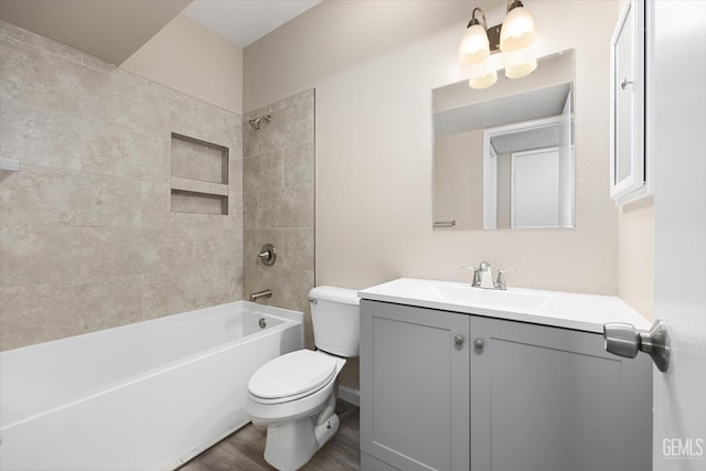 full bathroom with vanity, tiled shower / bath combo, toilet, and hardwood / wood-style flooring