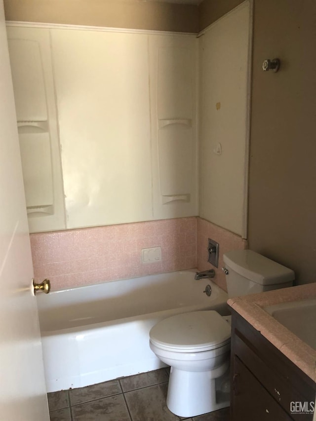 full bath with toilet, tile patterned flooring, vanity, and a tub to relax in