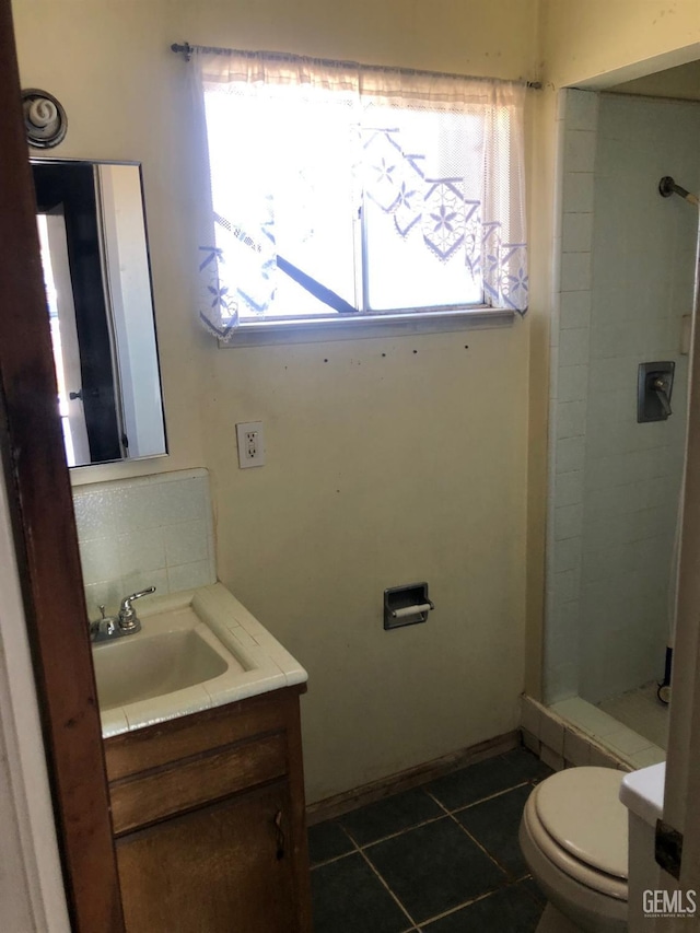 bathroom with vanity, tiled shower, and tile patterned floors