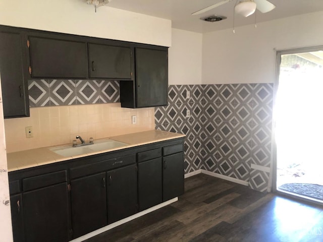 kitchen featuring a ceiling fan, dark wood-style flooring, a sink, backsplash, and light countertops