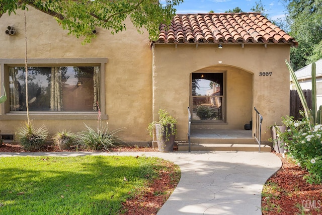 3007 Park Way, Bakersfield, CA 93304 - entrance to property featuring stucco siding, a yard, a porch, and a tiled roof