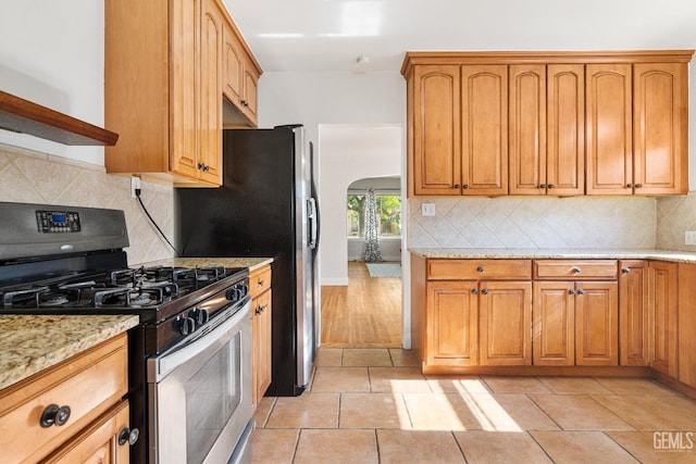 3007 Park Way, Bakersfield, CA 93304 - kitchen with stainless steel gas stove, arched walkways, light stone counters, and tasteful backsplash