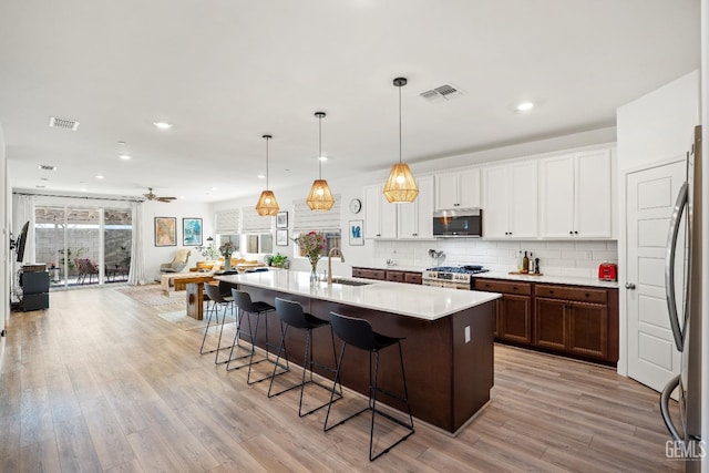6713 Diamond Springs Dr, Bakersfield, CA 93313 - kitchen with stainless steel appliances, a sink, a kitchen bar, recessed lighting, and light wood-style floors