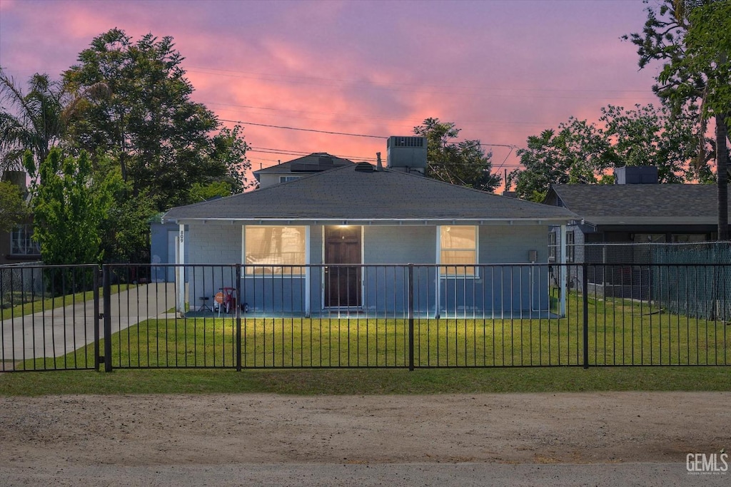 view of front facade featuring cooling unit, a front yard, and a fenced front yard