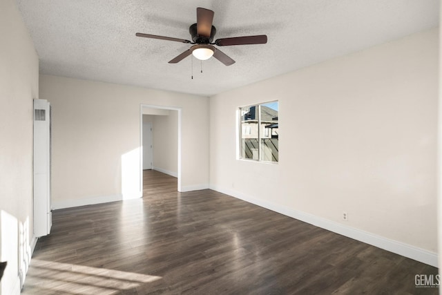 spare room featuring a textured ceiling, ceiling fan, and dark wood-type flooring