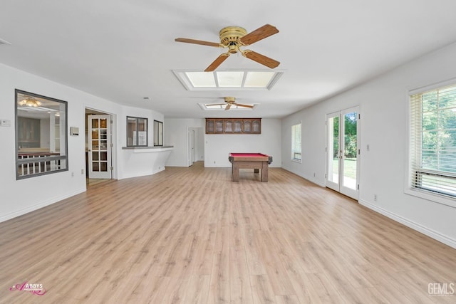 interior space with light wood finished floors, ceiling fan, billiards, baseboards, and a skylight