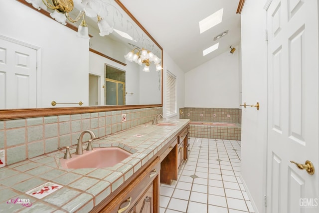 bathroom featuring tile patterned floors, a shower stall, vaulted ceiling with skylight, and a sink