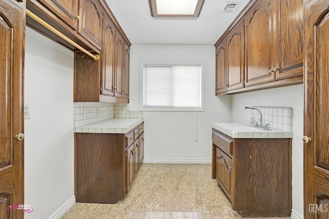 laundry area featuring baseboards, visible vents, and a sink